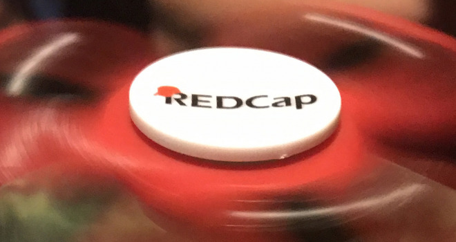 Red spinning fidget spinner with REDCap logo